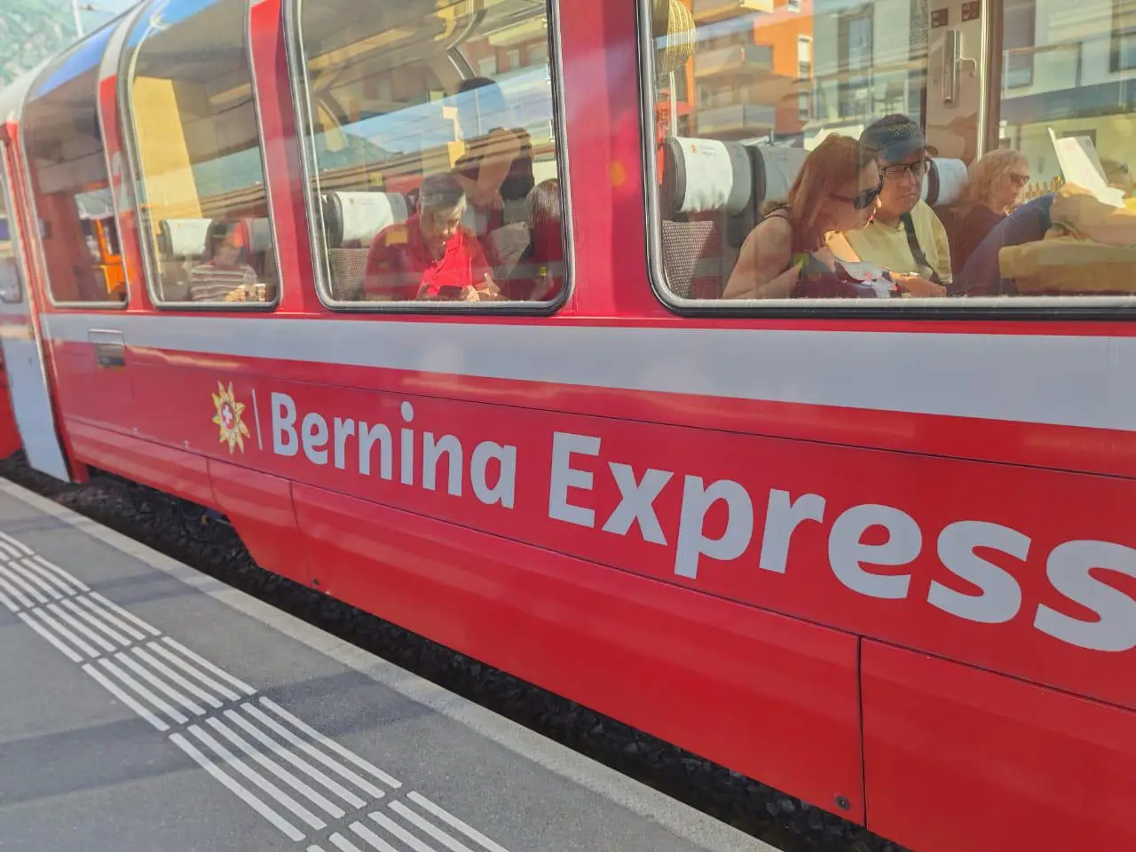 Viking Announces Zeppelin Airship Rides And New Offerings For European River Voyages 5 Red Bernina Express train at a station with passengers seated by panoramic windows on a Viking alpine land extension