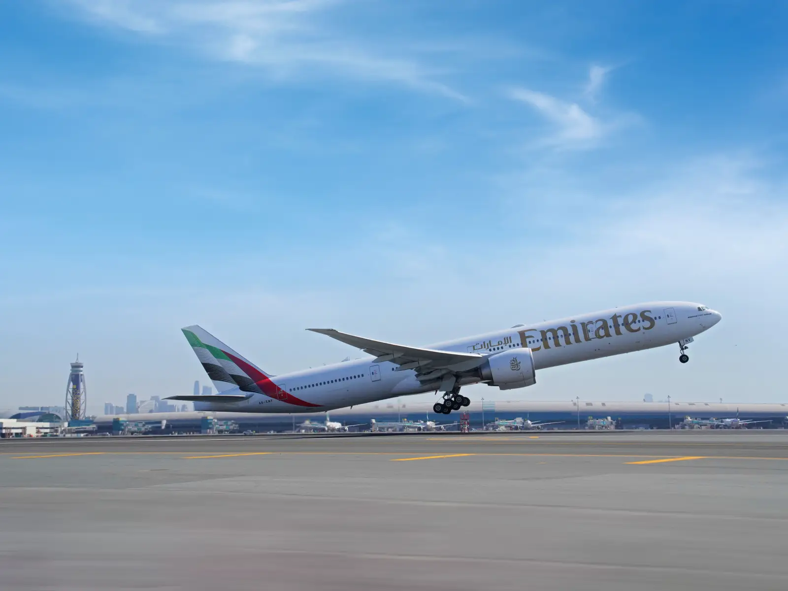 Emirates Seeks Daily Berlin And Stuttgart Flights With €100 Million Investment Pledge 3 An Emirates Boeing 777 lifting off from Dubai International Airport runway with the Dubai skyline and airport control tower visible in the background under a clear blue sky