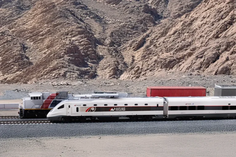 Rail Travel 12 Etihad Rail passenger train travels through a mountainous desert landscape in the United Arab Emirates