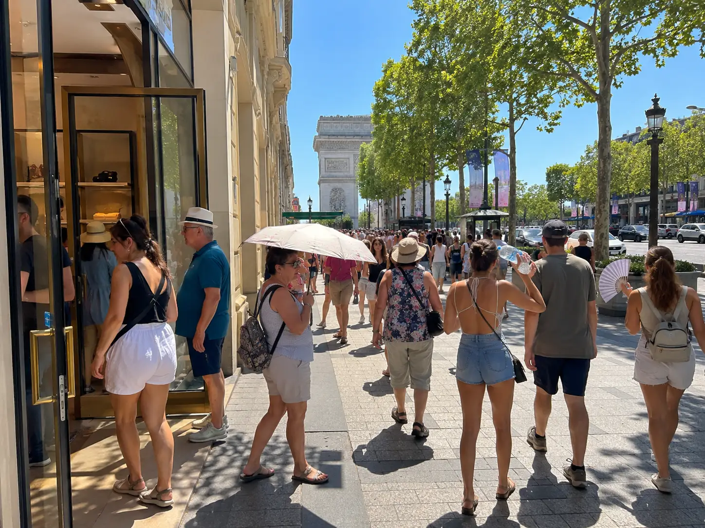 Tourists seek shade and air-conditioned shops on the Champs-Élysées in Paris during an intense European heatwave with temperatures above 35C.