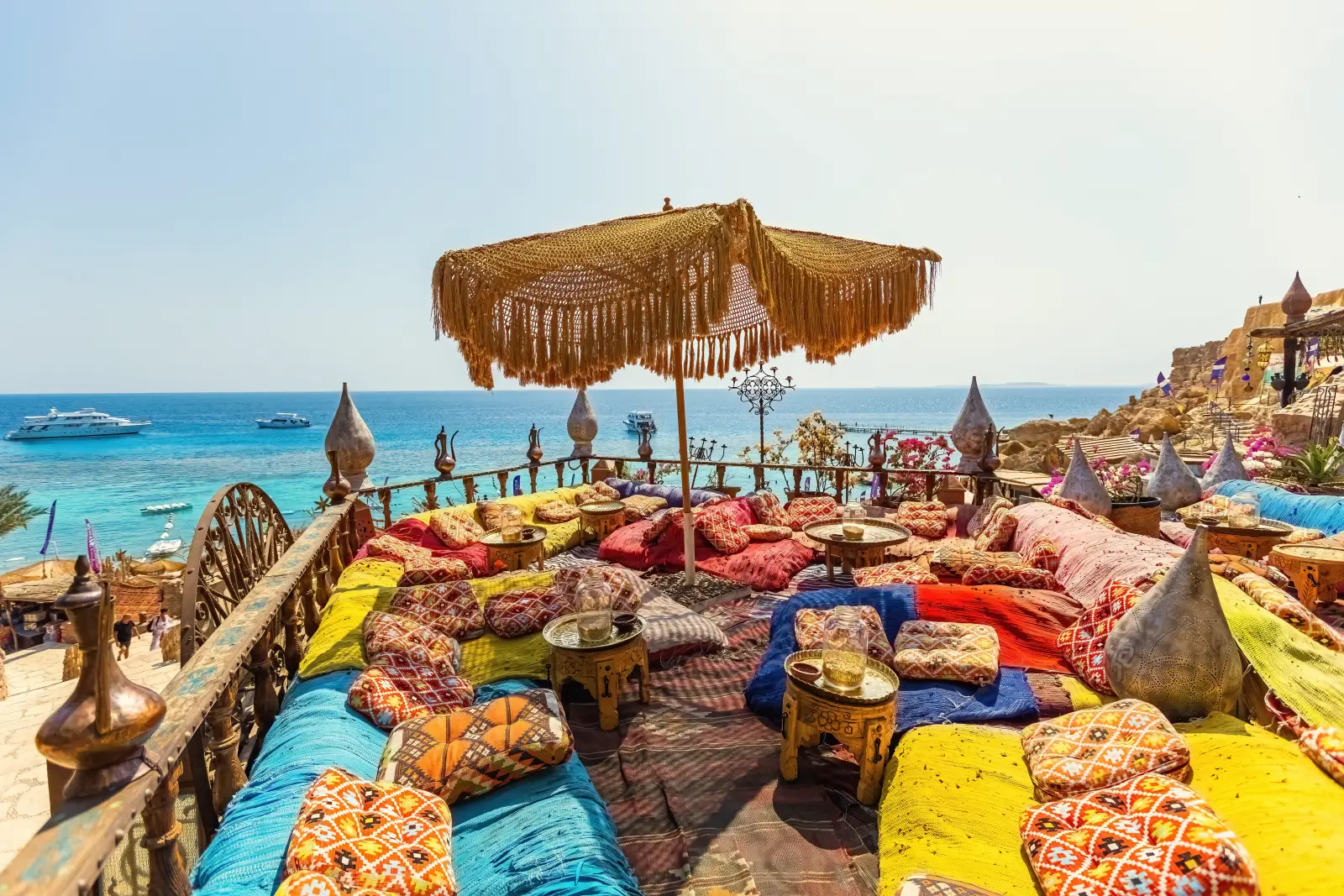 Türkiye Tourism Faces 10% Booking Slowdown As Prices Bite 3 Outdoor terrace seating at Farsha Café in Sharm El Sheikh overlooking the Red Sea, featuring colorful cushions, antique décor, and a traditional fringed parasol.