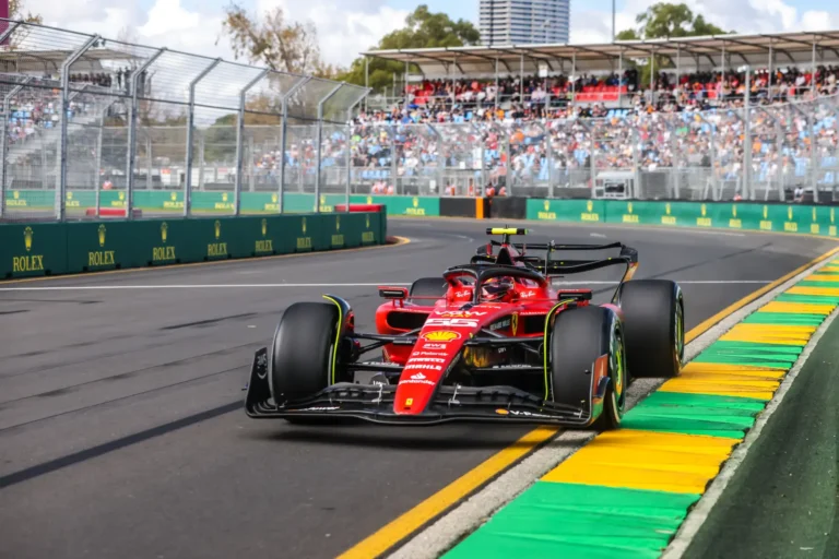Carlos Sainz driving the Ferrari SF-23 on the Albert Park street circuit during practice at the 2023 Australian Grand Prix in Melbourne, with packed grandstands visible in the background