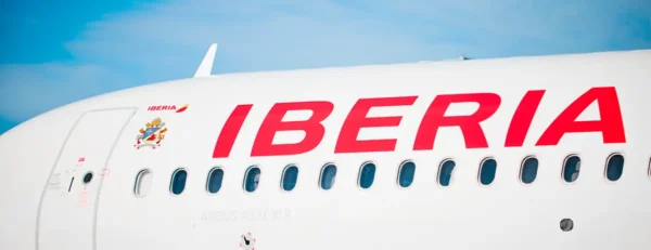 Close-up of an Iberia Airbus A321XLR aircraft fuselage with airline branding at the airport