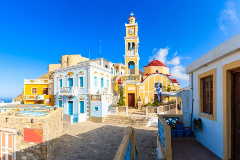 Colorful houses and a church with a clock tower in Olympos village, Karpathos, Greece.