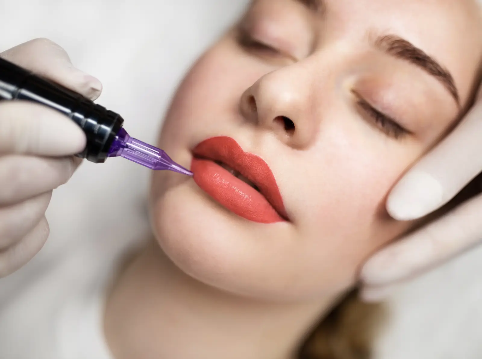 The &Quot;No-Makeup&Quot; Look: Why Lip Blush Is Dubai’s Top Beauty Trend In 2026 4 ALT Text: Close-up of a woman receiving a semi-permanent lip blush cosmetic treatment with a pigmentation device.