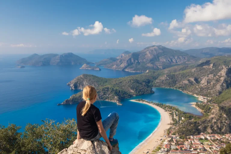Young girl overlooking Oludeniz Beach and the turquoise Mediterranean coast from the Lycian Way in Fethiye, Türkiye