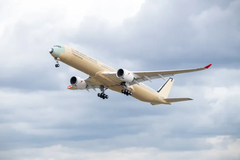 Aviation 13 The first Airbus A350-1000ULR built for Qantas climbing through a cloudy sky shortly after takeoff, shown in primer livery without final paint, with landing gear extended and "First A350-1000ULR for Qantas" and "Project Sunrise" titles visible on the forward fuselage.