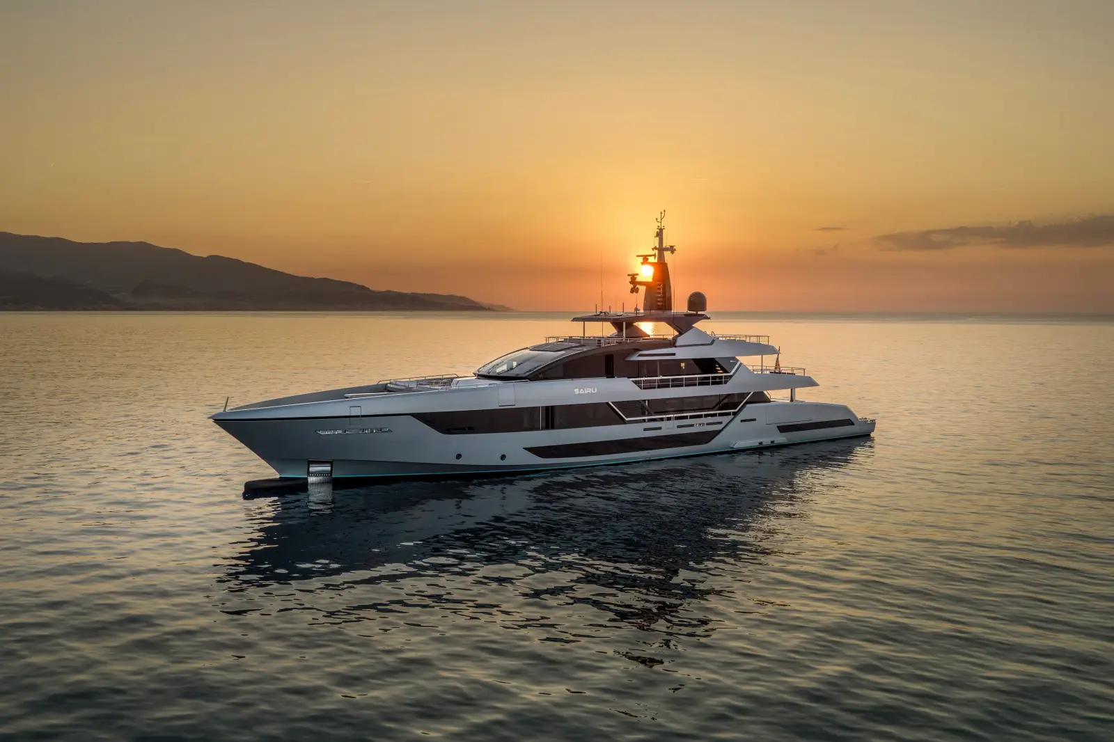 Riva 54Metri superyacht anchored on calm water at sunset, showing its sleek grey aluminium hull and four-deck profile against a golden sky