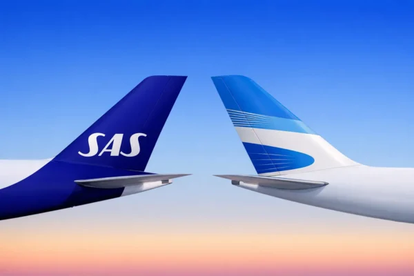 The tail fins of a SAS aircraft and an Aerolíneas Argentinas aircraft facing each other against a blue sky with a warm sunset gradient at the horizon