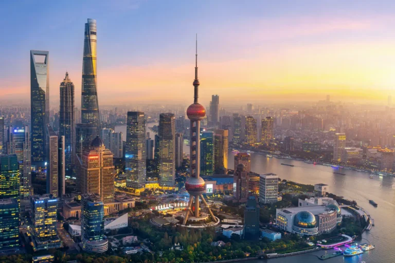 Aerial view of Shanghai's Lujiazui financial district at sunset, featuring the Oriental Pearl Tower and modern skyscrapers