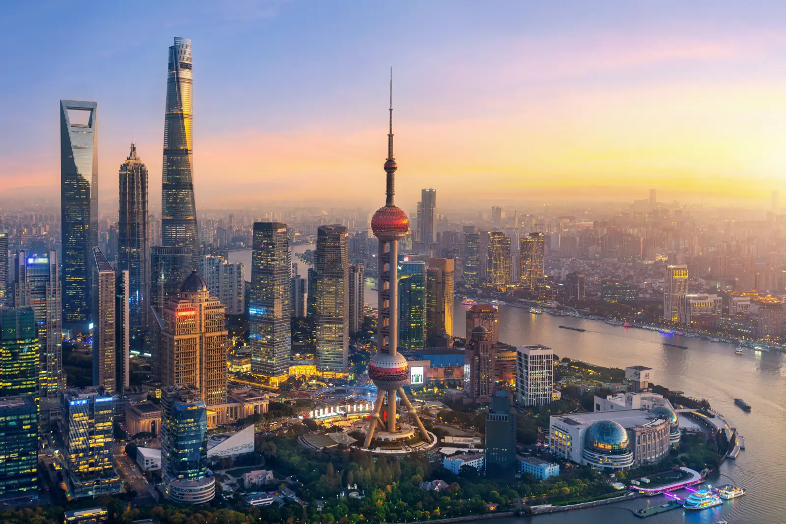 Aerial view of Shanghai's Lujiazui financial district at sunset, featuring the Oriental Pearl Tower and modern skyscrapers