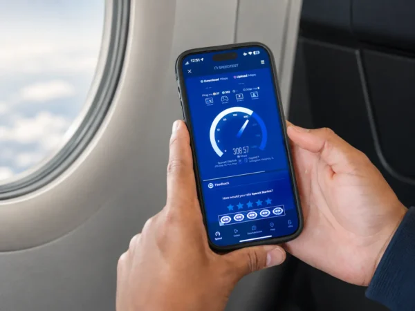 Passenger tests high-speed in-flight Wi-Fi on a smartphone while seated by an aircraft window