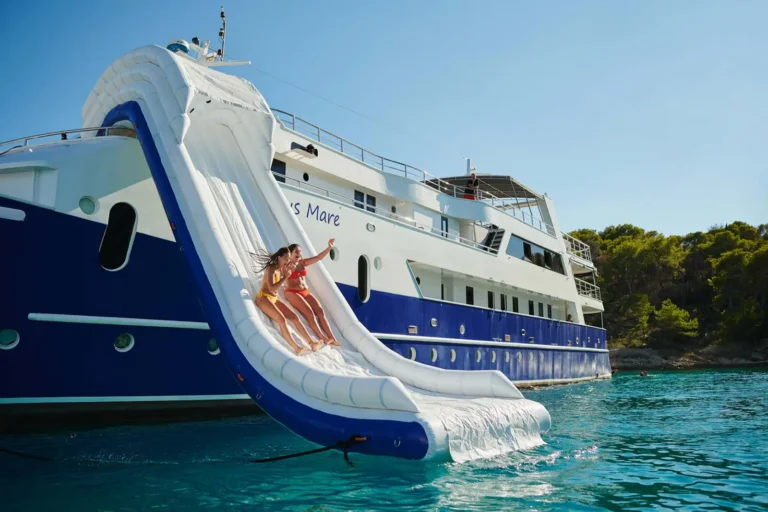 Cruise Travel 20 Two young guests slide down the inflatable waterslide off the Lupus Mare yacht into the turquoise Adriatic on a Tauck Bridges Croatia cruise