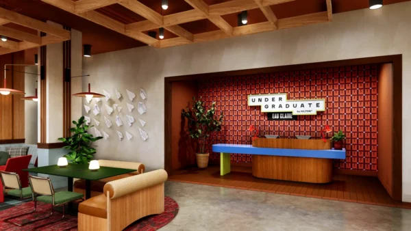 Rendering of the Undergraduate by Hilton hotel lobby featuring a colorful reception desk, lounge seating and campus-inspired interior design.