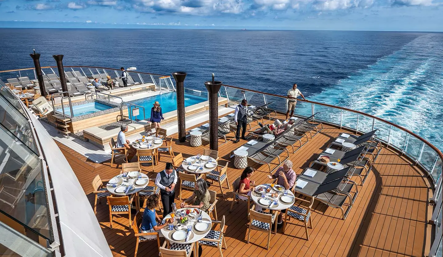 Viking Yidun Offers All-Mandarin Language Cruise For Mediterranean Season 5 Guests dining on the Aquavit Terrace open-air deck of Viking Yidun cruise ship, with a pool, sun loungers and open ocean views in the background
