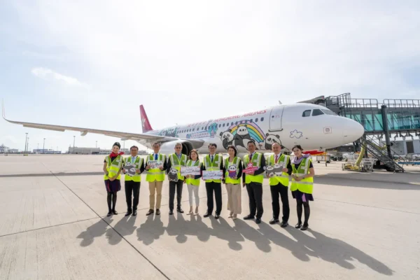 Hong Kong Airlines celebrates the launch of its Panda Friends themed aircraft with airline and Ocean Park representatives standing in front of the special livery at Hong Kong International Airport.