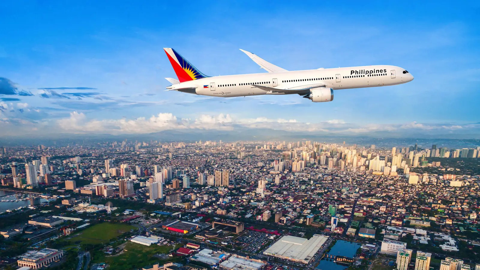 Philippine Airlines Signs For 15 Boeing 787S, With Rights For Five More 4 A Philippine Airlines Boeing 787-9 Dreamliner flies above the Manila skyline under a clear blue sky.