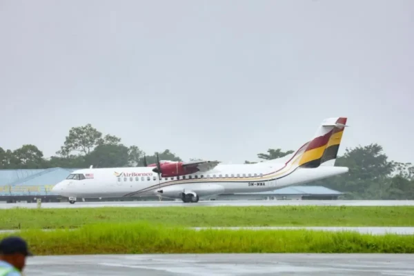 News 26 AirBorneo ATR 72 aircraft on the runway at Kuching International Airport during wet weather.