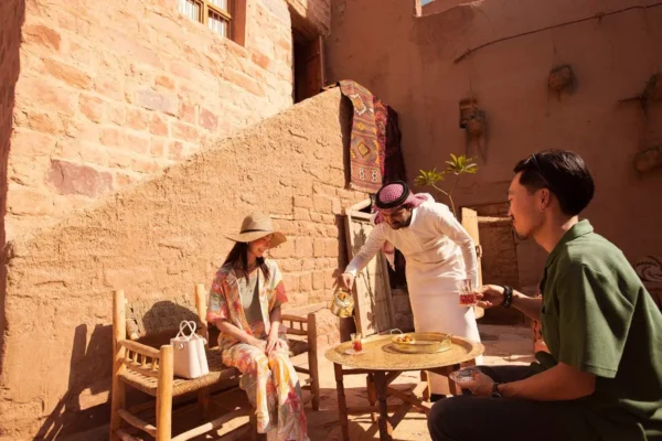 Home 13 Chinese travellers enjoy traditional Saudi hospitality with tea in AlUla Old Town.