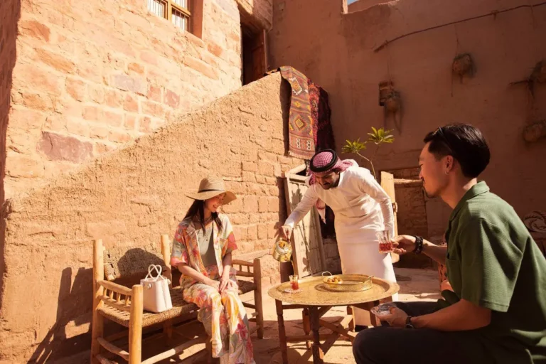 Chinese travellers enjoy traditional Saudi hospitality with tea in AlUla Old Town.