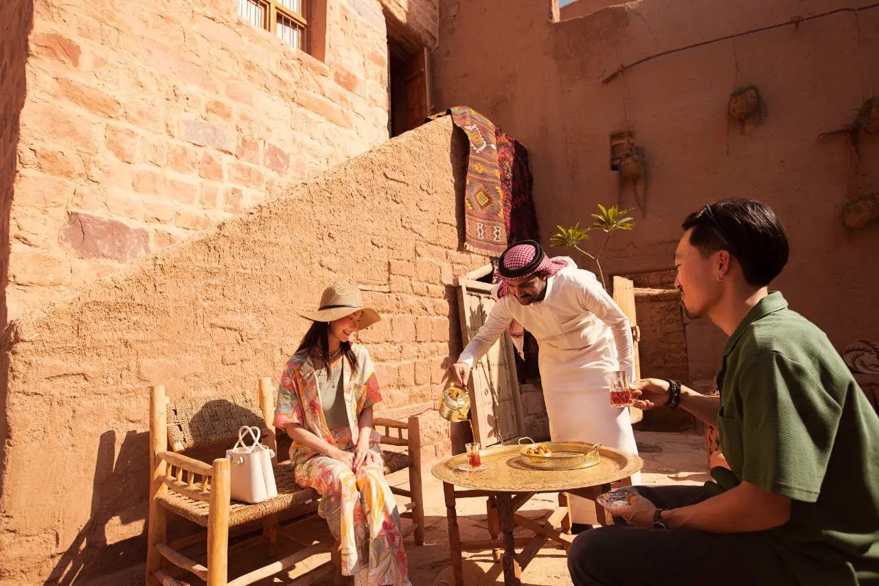Chinese travellers enjoy traditional Saudi hospitality with tea in AlUla Old Town.