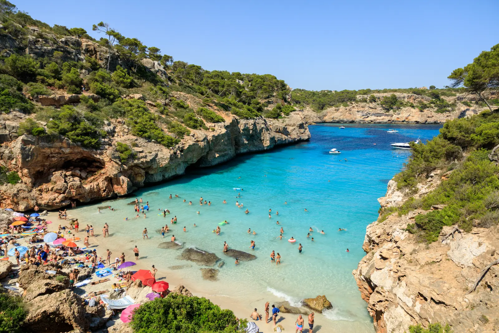 Spain'S Hottest Week Yet: Third Heatwave To Bring 45C Highs 3 Crowded beach and turquoise cove at Cala des Moro, Mallorca, Spain