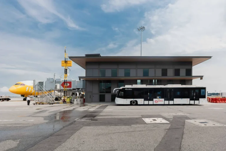 Changi Airport’s satellite gate with an airport bus and aircraft parked at a remote stand.