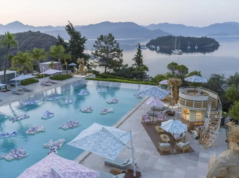 Aerial view of the infinity pool and seaside terraces at D Maris Bay overlooking islands and yachts on Türkiye's Datça Peninsula.