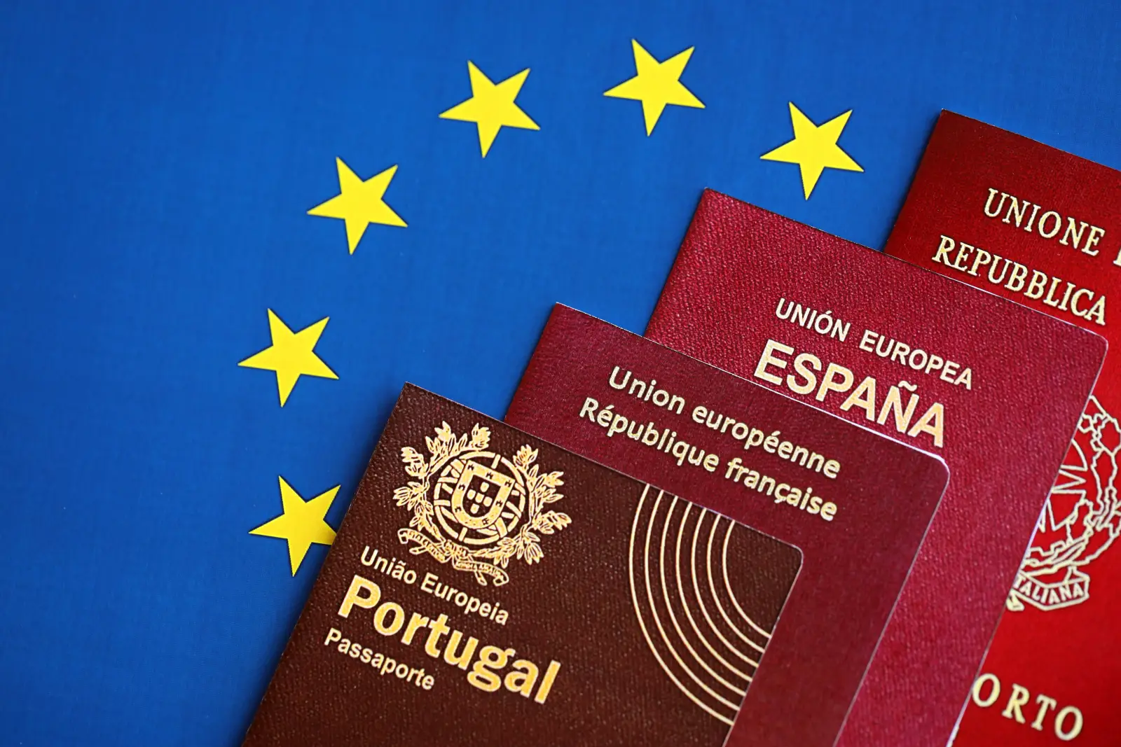 Visa-Free Does Not Always Mean Fee-Free For Europeans 3 Portuguese, French, Spanish and Italian passports arranged over the European Union flag.