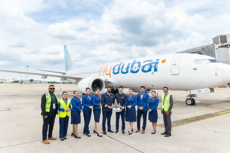 flydubai crew and airport staff celebrate the inaugural Dubai to Bangkok flight beside a Boeing 737 MAX at Don Mueang Airport.