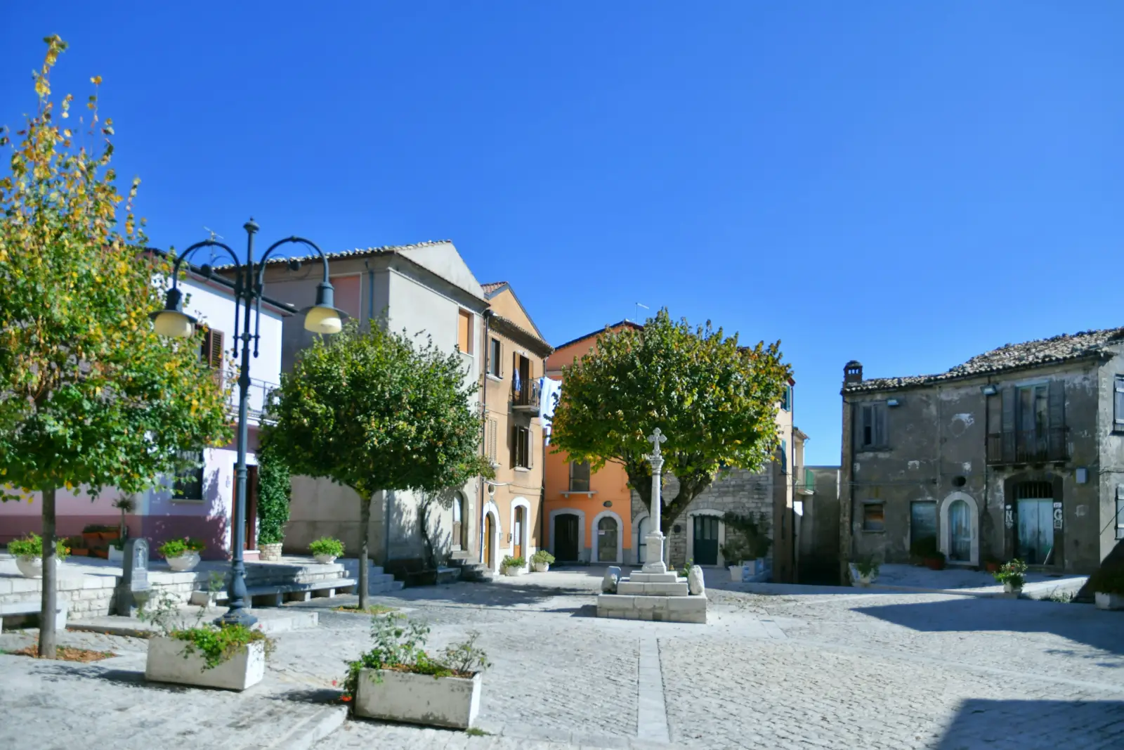 Small square with historic stone buildings in Frosolone, a medieval village in Italy's Molise region.