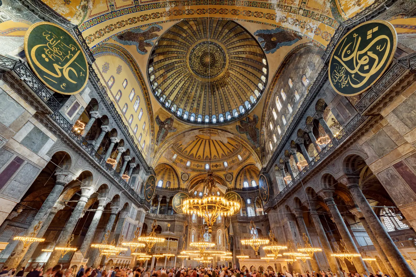 Hagia Sophia: 2 Russian Tourists Arrested After Bible Reading 3 Interior of Hagia Sophia in Istanbul featuring its vast dome, Islamic calligraphy and illuminated chandeliers.