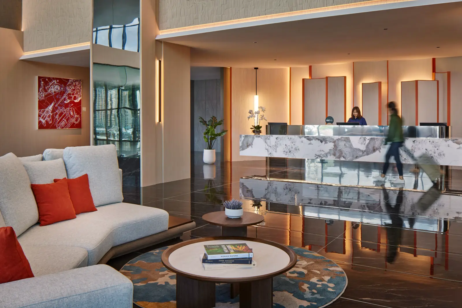 Modern lobby of HARRIS Hotel & Conventions Sunshine Penang featuring a spacious reception area, contemporary seating and a guest checking in.