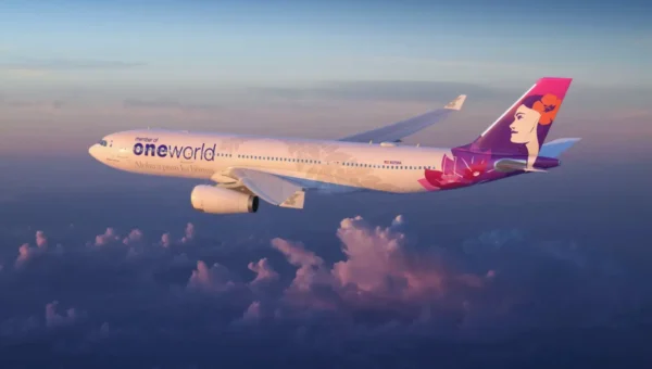 Home 5 Hawaiian Airlines Airbus A330 in special oneworld alliance livery flying above clouds at sunset.