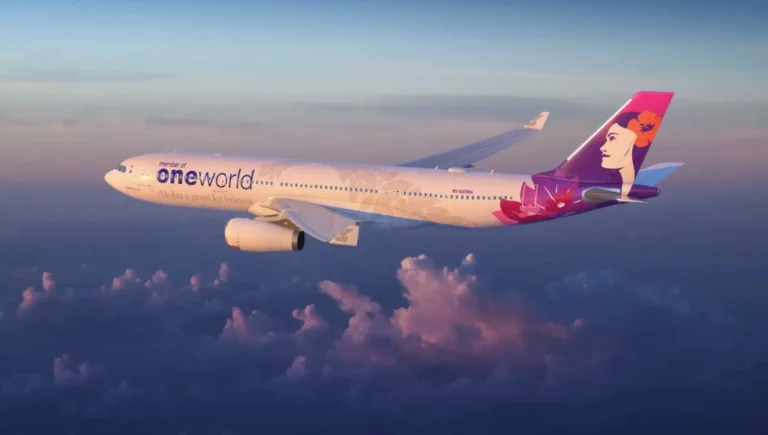 Hawaiian Airlines Airbus A330 in special oneworld alliance livery flying above clouds at sunset.