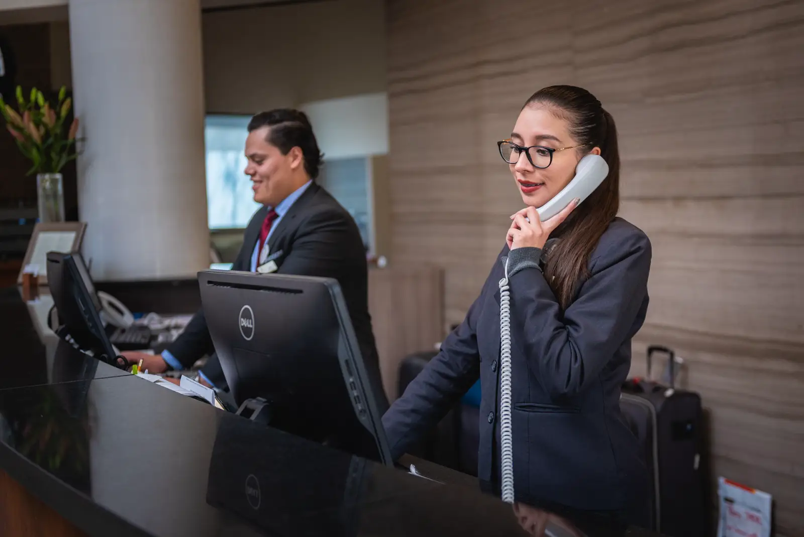 Hotel reception staff assisting guests at the front desk