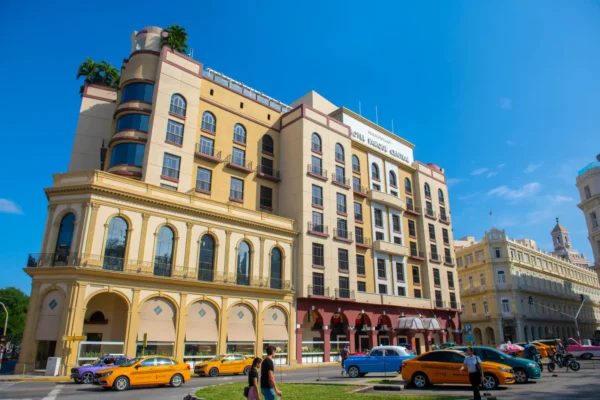 Home 12 Iberostar Parque Central hotel building with taxis and classic cars parked outside in Old Havana, Cuba
