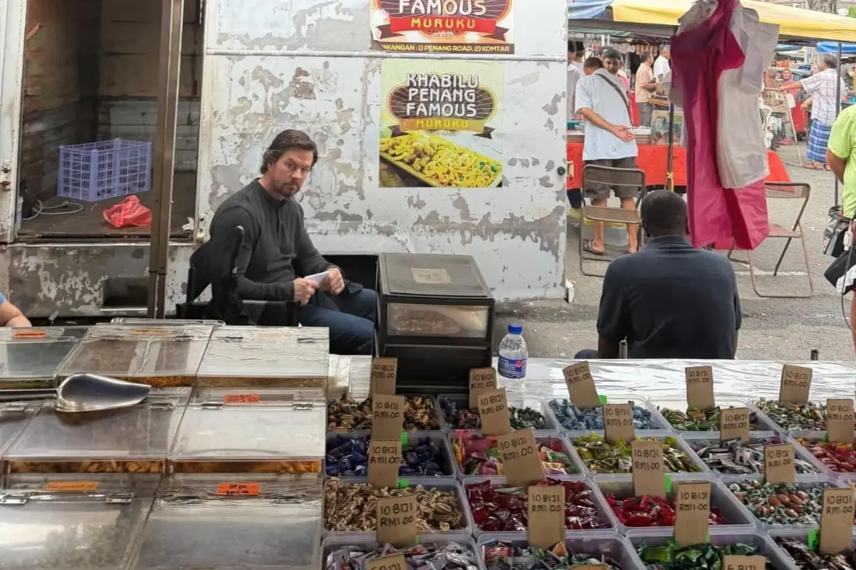 Hollywood Star Mark Wahlberg Filming Scenes In Penang For Netflix’s New Movie 3 Mark Wahlberg sits beside a snack stall at a busy Penang market.