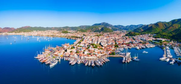 Home 9 Aerial panoramic view of Marmaris Marina and waterfront with yachts, the historic castle and surrounding mountains in Muğla, Türkiye.