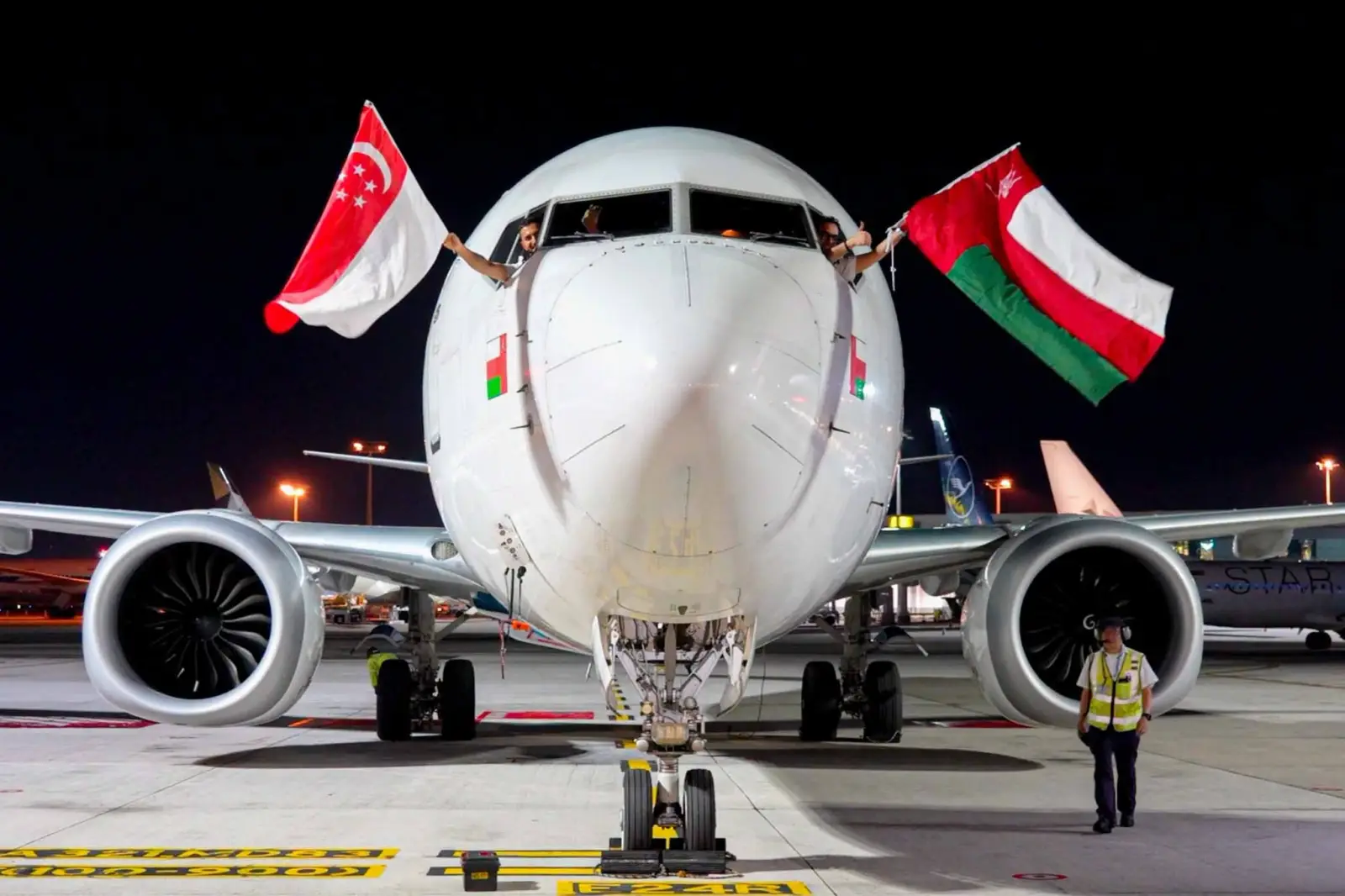Oman Air Launches Direct Services To Singapore And Tashkent 3 Oman Air pilots display the flags of Oman and Singapore from the cockpit after the inaugural direct flight between Muscat and Singapore.
