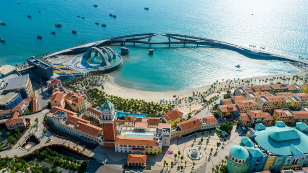 News 42 Aerial view of Phu Quoc Island featuring Sunset Town, Kiss Bridge, turquoise waters, sandy beaches, and the Gulf of Thailand coastline.