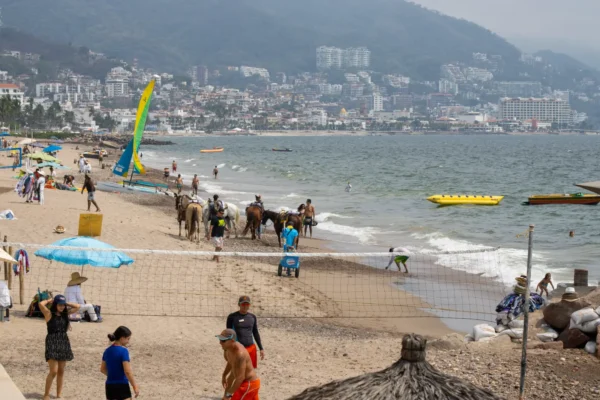 Visitors enjoy the beach and water activities along the coast of Puerto Vallarta, Mexico.