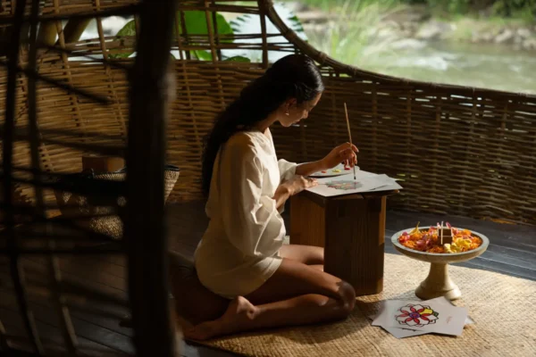 News 29 Guest enjoys a mindful painting activity in a riverside pavilion, reflecting the quiet luxury and wellness travel experiences highlighted in Marriott's Asia Pacific report.