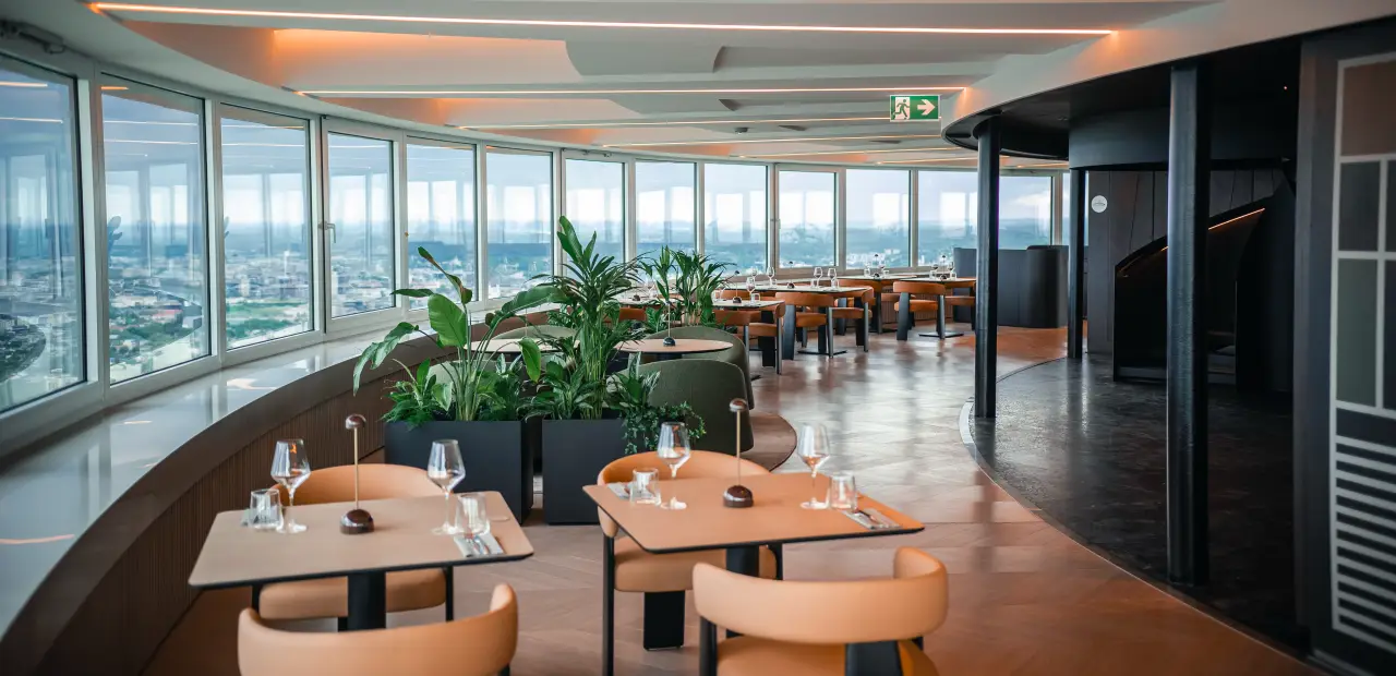 Interior of the rotating Milky Way restaurant at Vilnius TV Tower, with curved panoramic windows overlooking the city