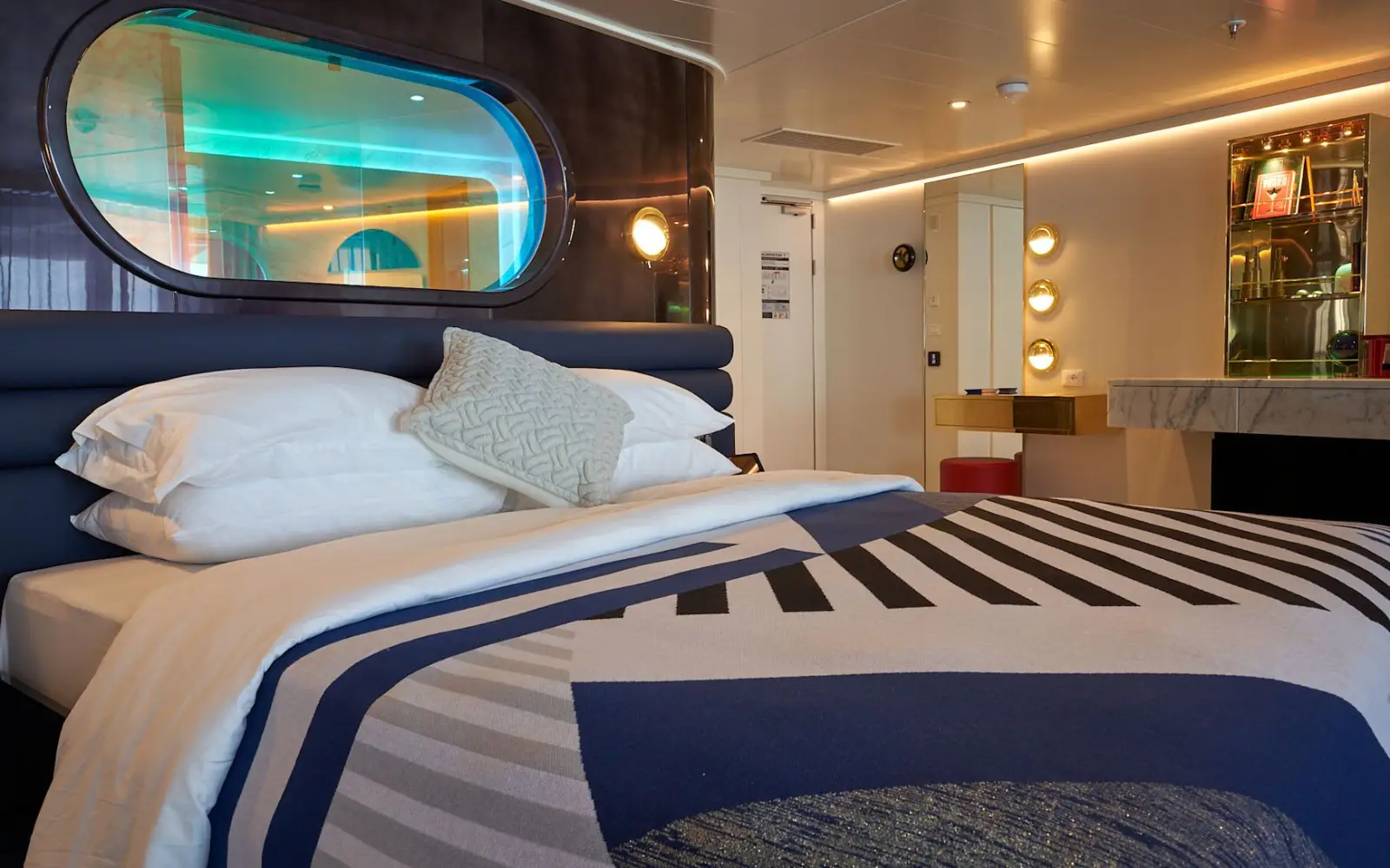 Virgin Voyages Unveils Solar Eclipse Cruises Featuring Nasa Astronauts 4 Interior of a Virgin Voyages suite featuring a king-size bed, modern design and stylish lounge area aboard the cruise ship.
