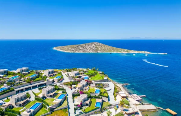 Aerial view of villas overlooking Yalıkavak Bay and the turquoise Aegean Sea in Bodrum, Turkey.